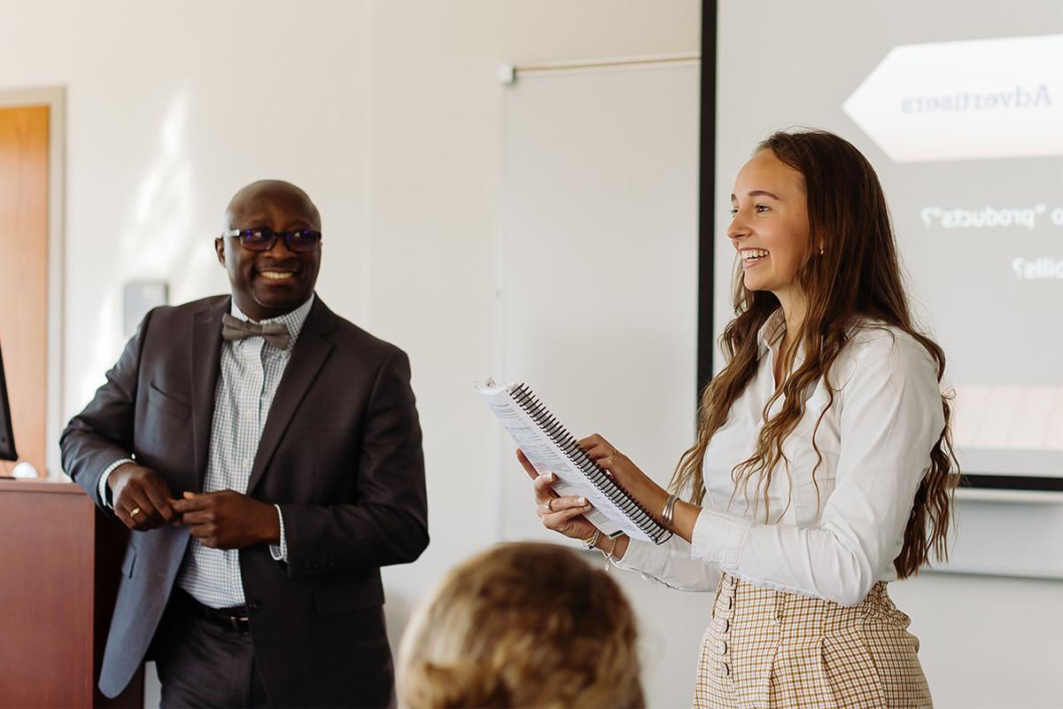 a student happily presenting to an attentive class